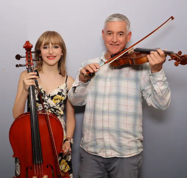 A teenage cellist and her dad playing the violin