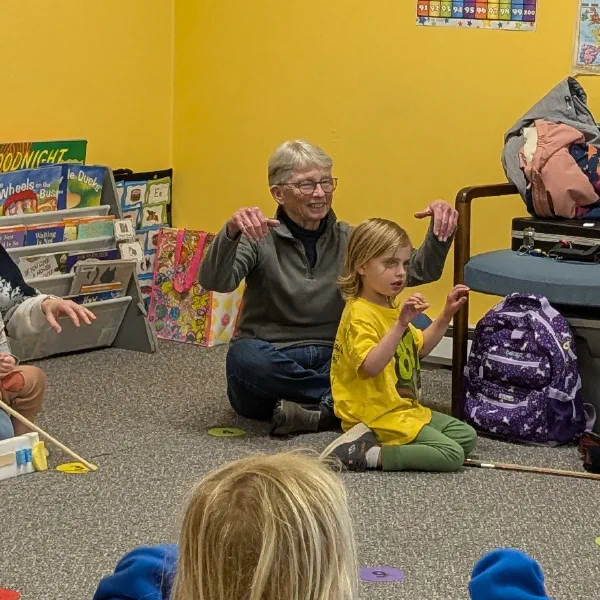 A young Sound Sprouts student and her grandmother doing music and movement together in class